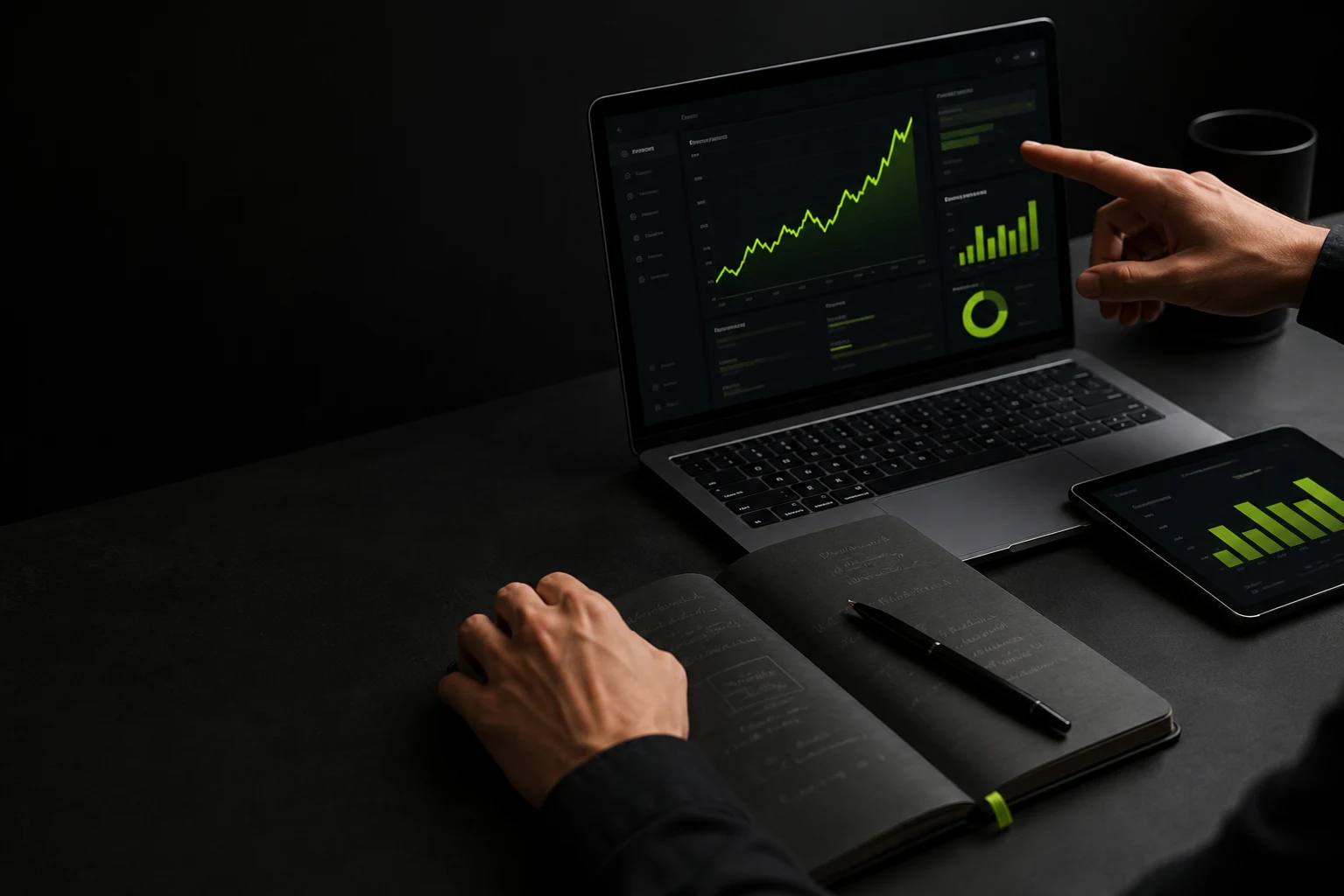 Two people reviewing SEO analytics on a laptop and tablet at a dark workspace