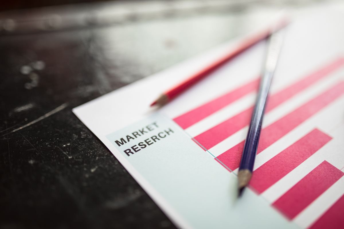 A pen resting on a printed research document beside a bar chart